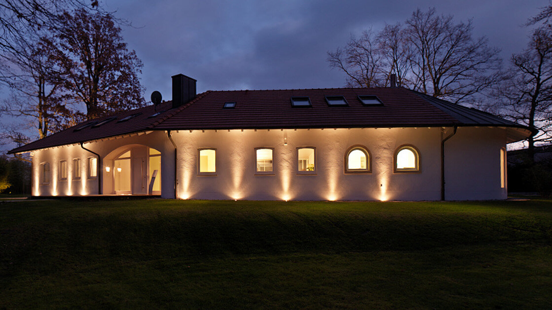 Hauptgebäude von Corivus bei Nacht Das Bild zeigt eine Villa, die im Dunkeln wunderschön beleuchtet ist.