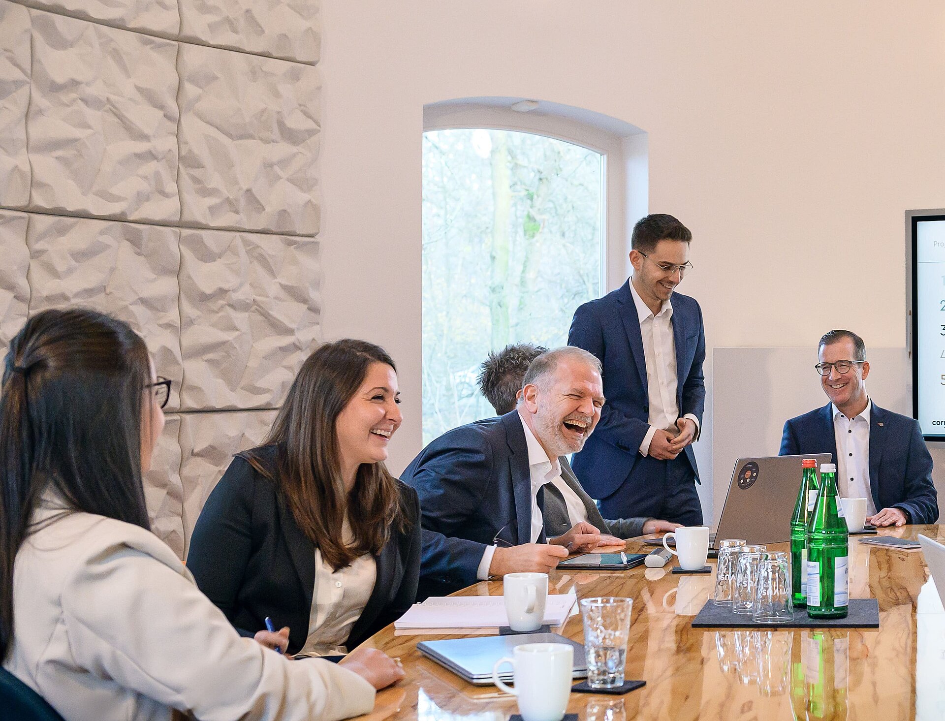 Corivus Team mit Spaß bei der Arbeit Fröhliches Corivus Team im Meetingraum